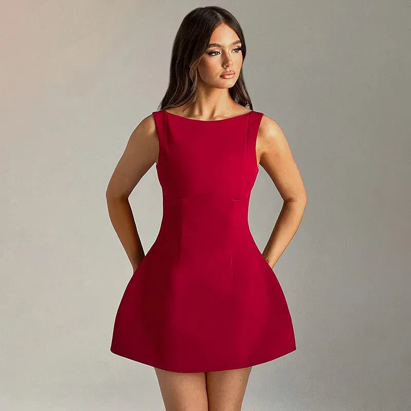 A woman wearing a slim-fitting black backless sleeveless summer dress with a high waist and short skirt.