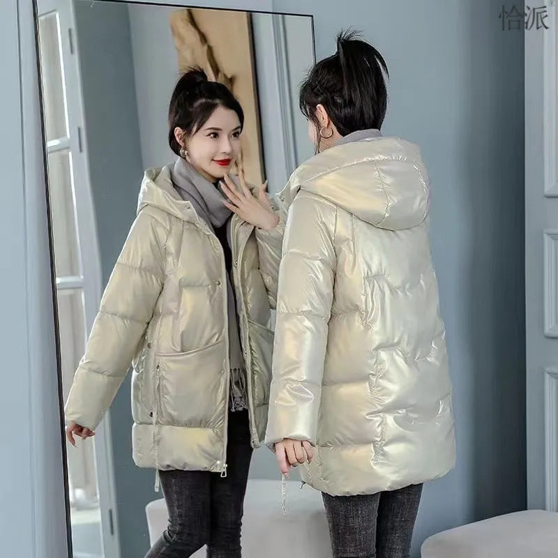 A woman wears a loose-fitting green hooded winter jacket with long sleeves.
