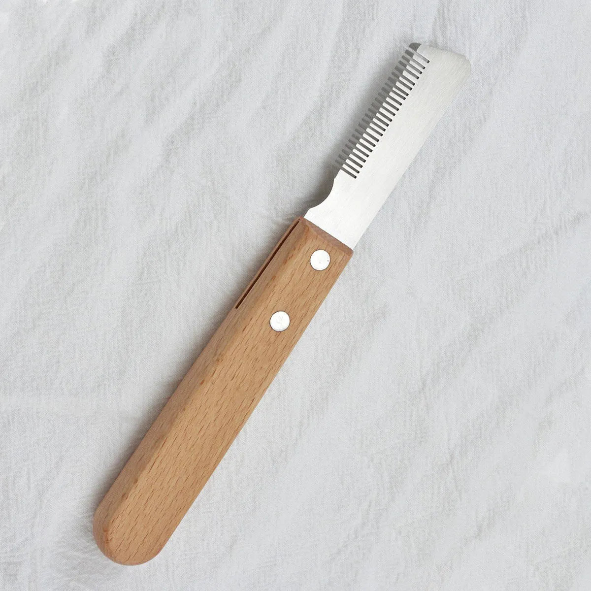Pet stripping comb with wooden handle and metal teeth for removing hair from dogs and cats.