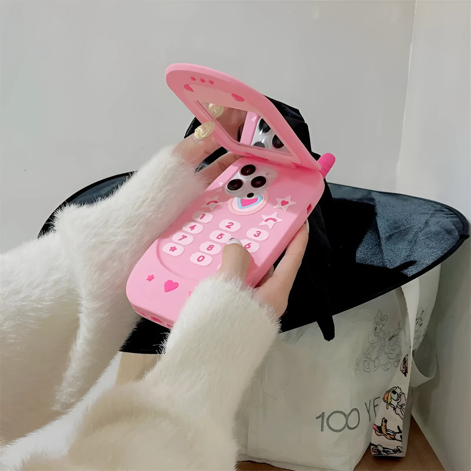 Pink silicone flip phone shape case with a mirror, designed for iPhone models.