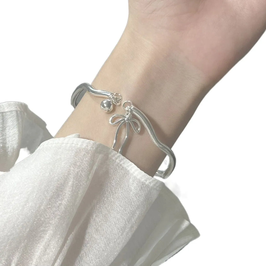 Silver adjustable bracelet with bow charm and sliding clasp mechanism