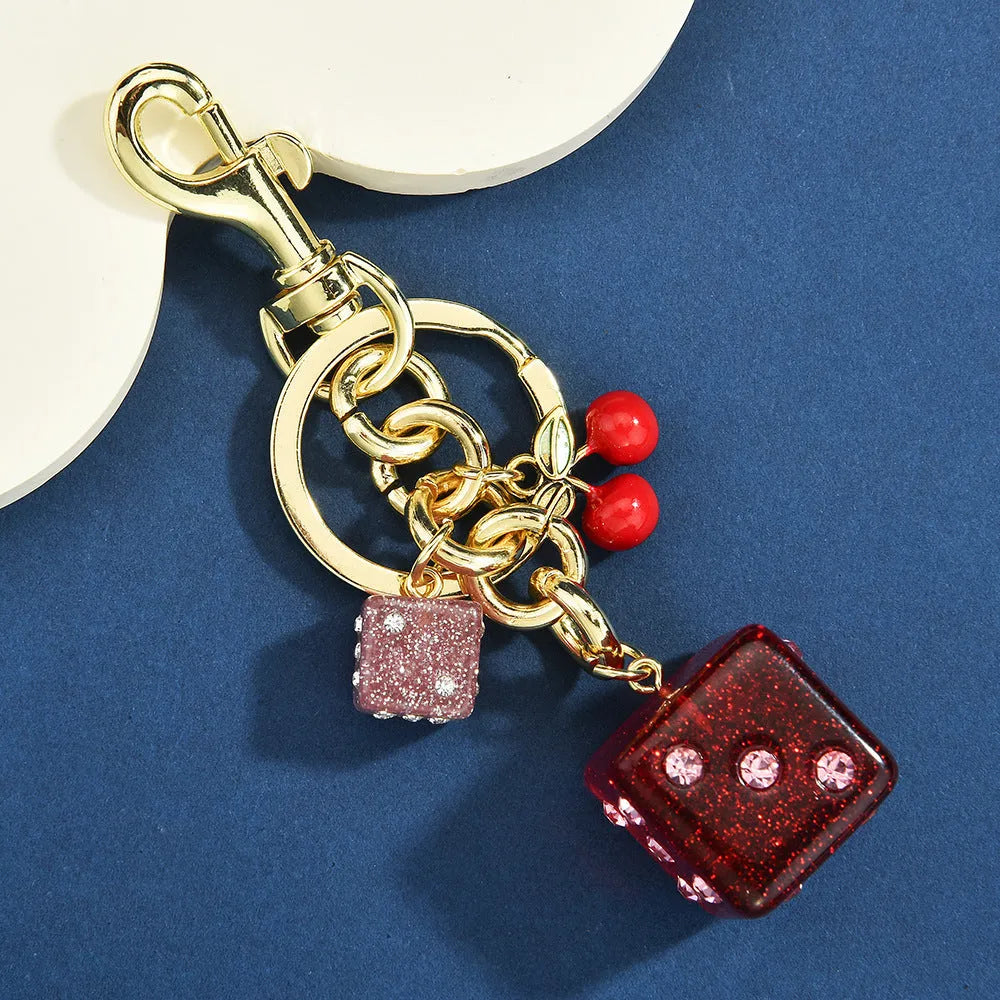 Vintage cherry two-tone dice design on a square electroplated metal keychain pendant.