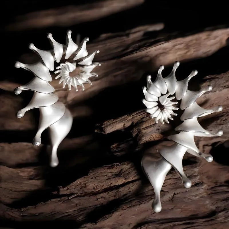 A pair of matte conch-coloured alloy stud earrings with an exaggerated three-dimensional shape.
