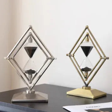 Glass sand clock with metal base showing coloured sand, in bronze or silver finish options.