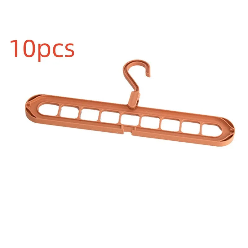 Green plastic multifunctional hanger with nine arms for folding trousers, shown hanging on a rail.