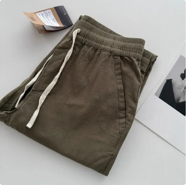 Men's beige loose-fit straight-leg casual pants with a drawstring waistband on a hanger.