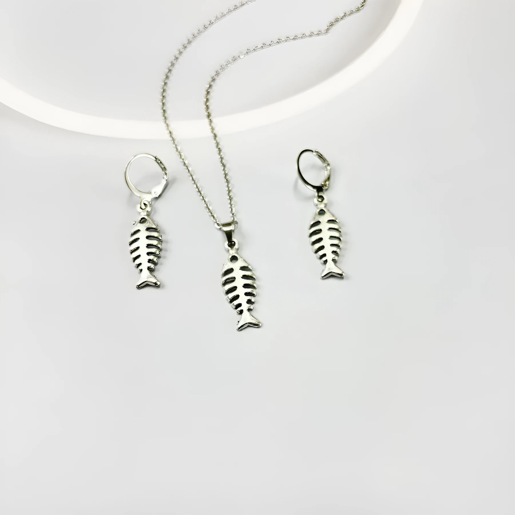 Women's fishbone pendant alloy necklace and matching earrings set on a white background