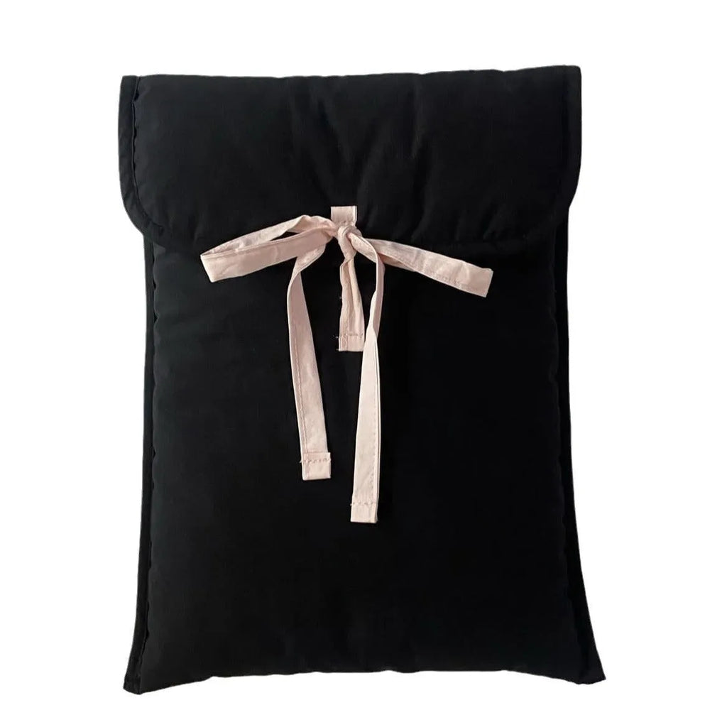 Women's black quilted computer bag with ballet bow detail showing striped nylon lining