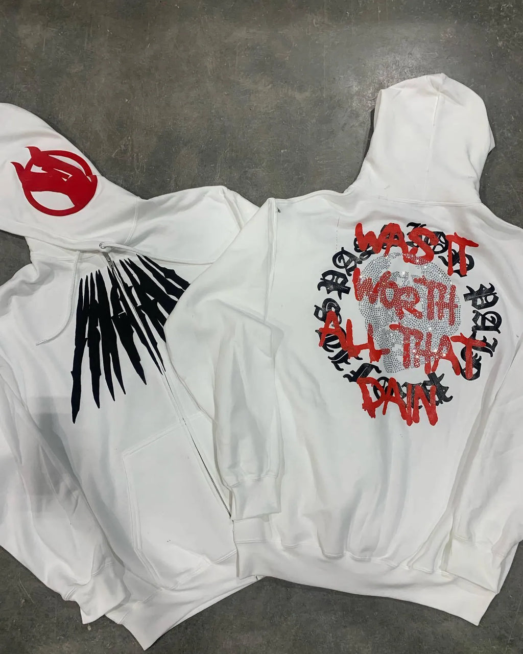 Black hooded sweatshirt cardigan with a white printed skull and rhinestone design on the front.