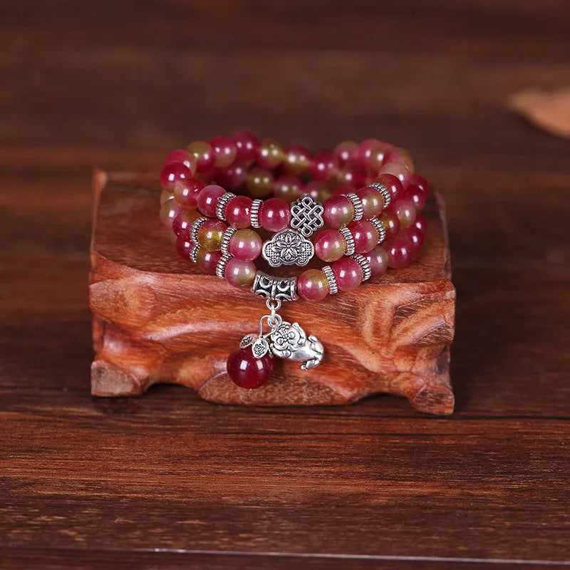 Handmade bracelet with a watermelon crystal elephant bead on a Chinese knot cord.