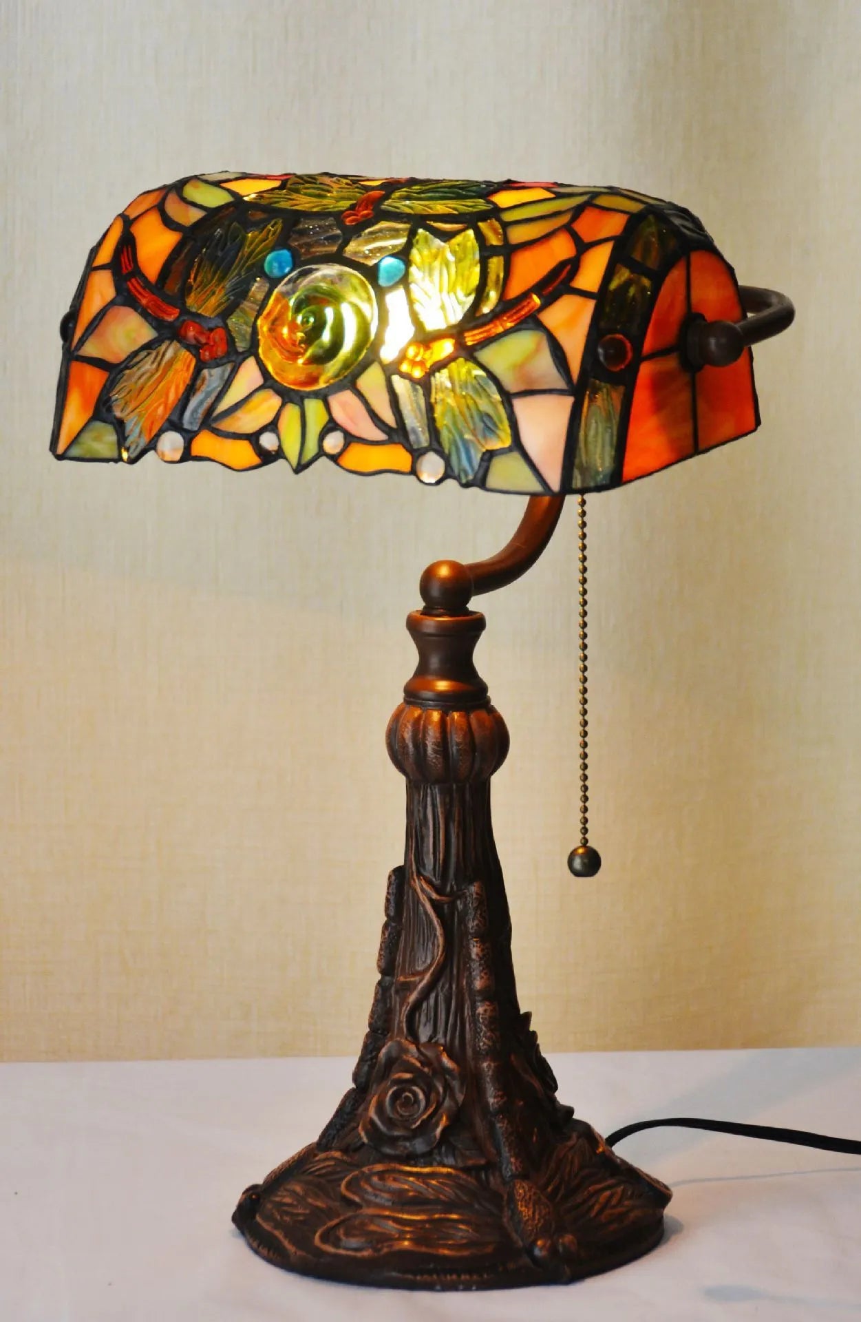 10-inch Tiffany desk lamp with coloured stained glass shade and resin base on a table.