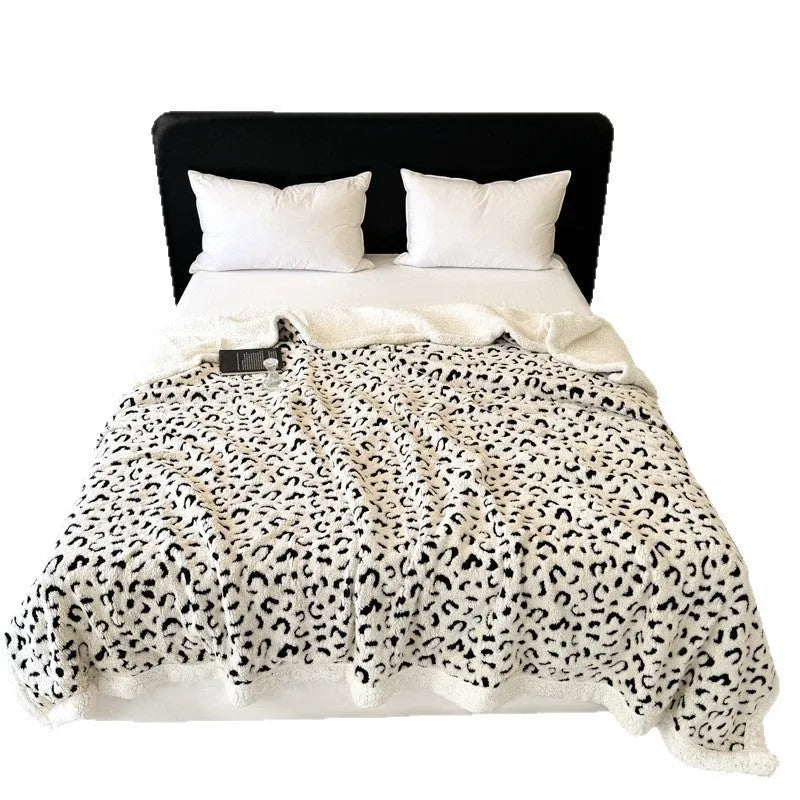 Double-layer Jacquard taffeta blanket with leopard print design in camel colour folded to show texture and pattern detail