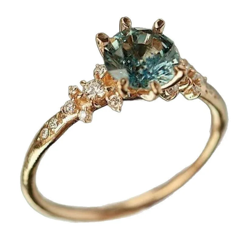 Gold geometric ring with claw-set zircon stones and chamfered square patterns