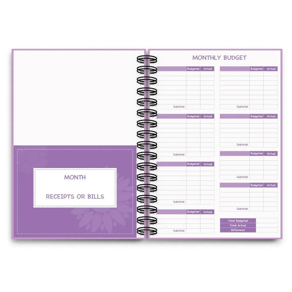 Purple coil-bound budget notebook open showing monthly planning pages with financial stickers and paper clips