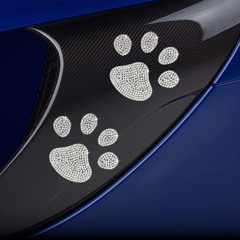 Close-up of a diamond-encrusted glass car sticker in a butterfly or bear claw design on a white background.