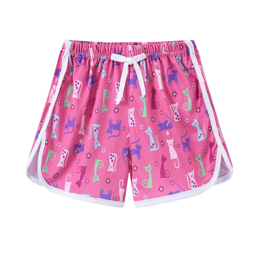 Children's patterned beach shorts in various colours including leopard print, floral, and fruit designs