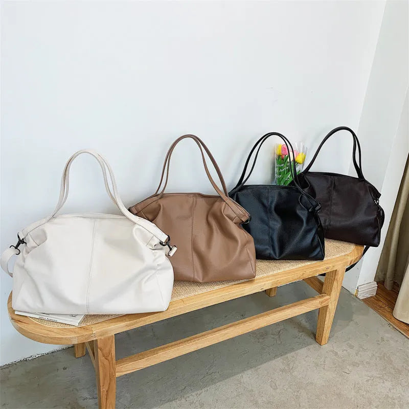 Large soft black PU messenger bag with car suture detail, shown with zip open revealing organiser pockets.