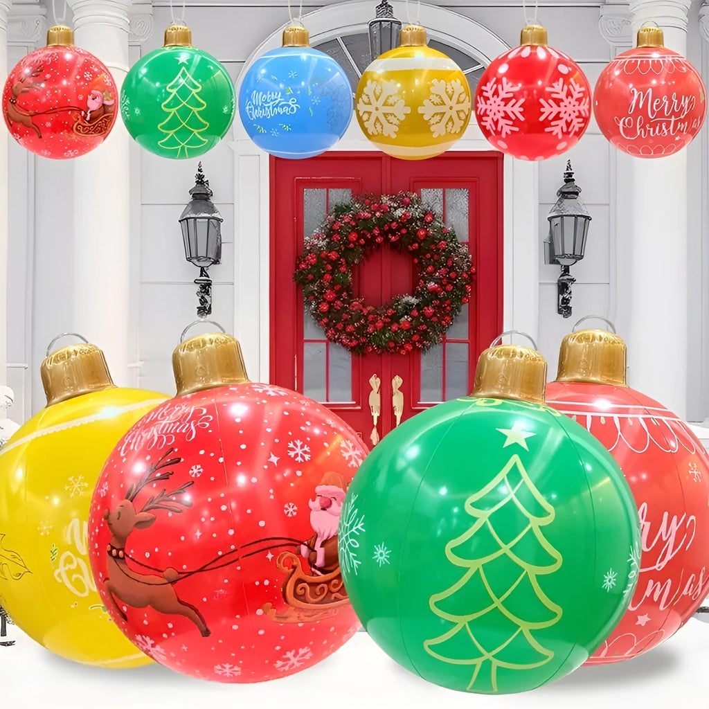 Large red inflatable Christmas ball with snowflake design and flashing LED lights in a garden.