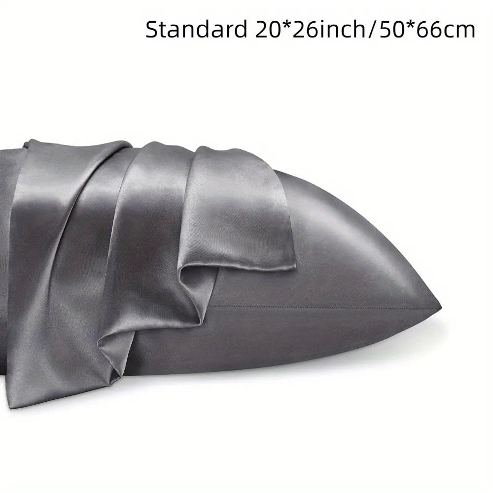 A pair of solid colour satin pillowcases in various colours and sizes on a bed.