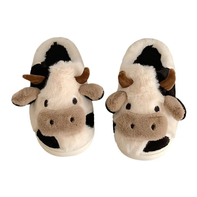White cow plush slippers with non-slip textured soles shown from above