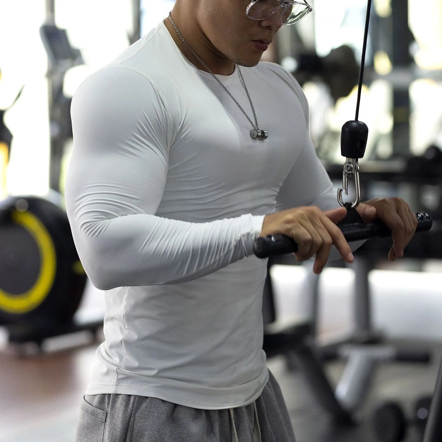 Man wearing black long-sleeved slim-fit fitness tights for gym workout or running.