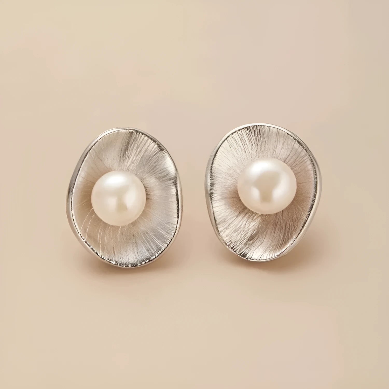 A pair of gold-coloured geometric sterling silver stud earrings featuring a single pearl.
